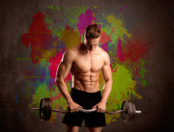 Δυνατός τύπος με πολύχρωμο χρώμα τοίχου και βάρους - Φωτογραφία, εικόνα