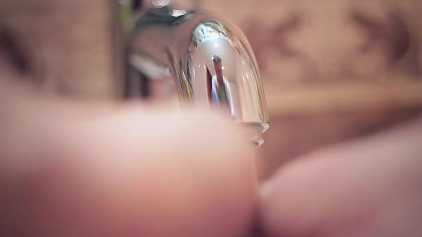 Turning off tap, close up of adult hand turning off water - Footage, Video