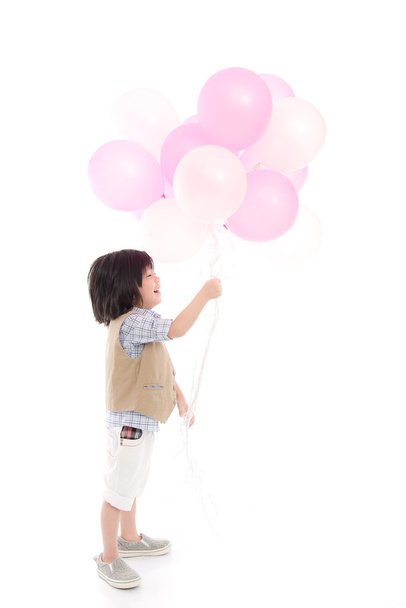 Bambino asiatico che tiene palloncini rosa e bianchi
 - Foto, immagini