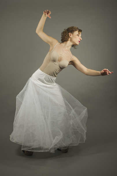 Young expressive ballerina with a white long tutu practicing bal - Fotografie, Obrázek
