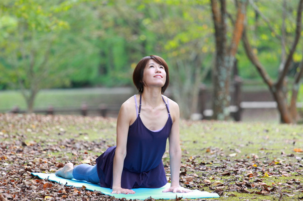 Japanerin draußen macht Yoga-Kobra-Pose - Foto, Bild