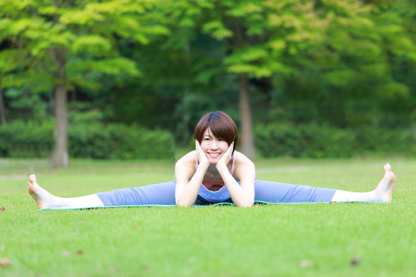 portrait of Japanese woman outside doing stretches exercise - Fotoğraf, Görsel