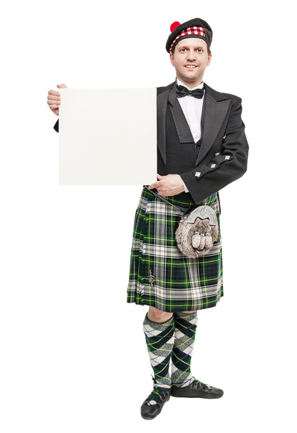 Joven en ropa para baile escocés con pancarta vacía
 - Foto, imagen