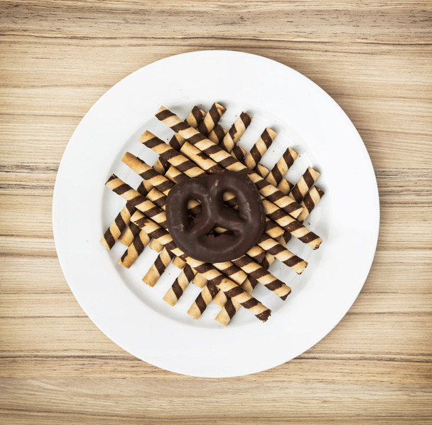 Rouleaux de chocolat savoureux et biscuit au pain d'épice sur la plaque blanche
 - Photo, image