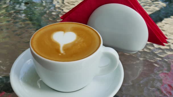 Cappuccino s láskou na skleněný stůl - Záběry, video