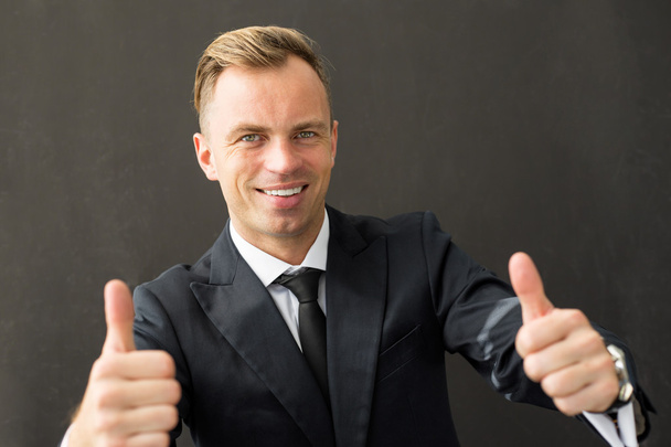 Щасливий бізнесмен показує обидва великі пальці вгору
 - Фото, зображення
