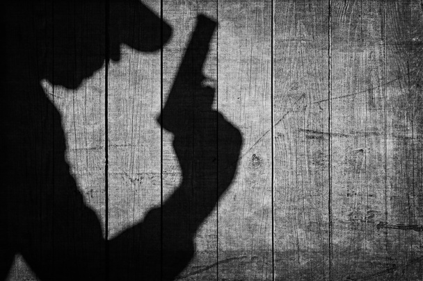 Black Armed Male Silhouette On The Wooden Fence. - Zdjęcie, obraz