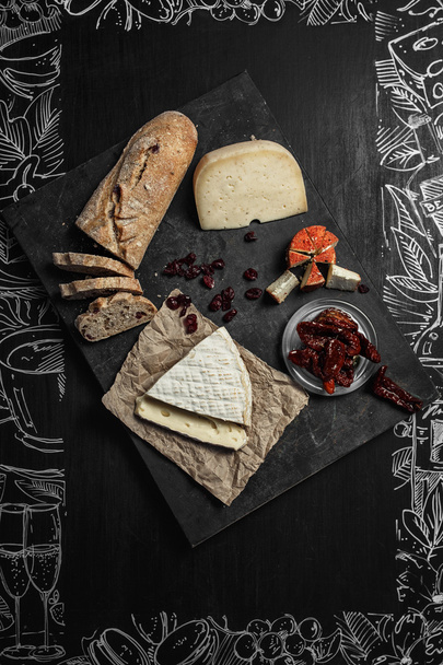 Wine appetizers set: cheese selection, bread sticks and prunes on the wood serving board background. Top view - Φωτογραφία, εικόνα