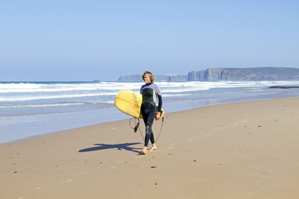 Surfer zu Fuß am Strand entlang - Foto, Bild