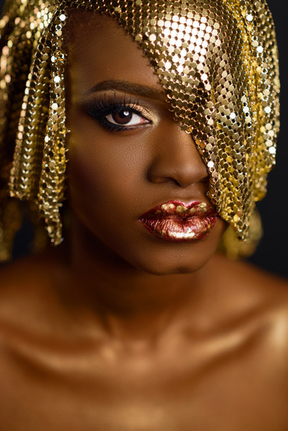 High fashion portrait of young african american female model with gold glossy makeup and hairstyle. Face art. - Valokuva, kuva
