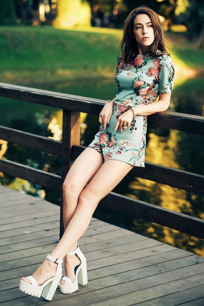 Fashion brunette woman posing on the bridge - Valokuva, kuva