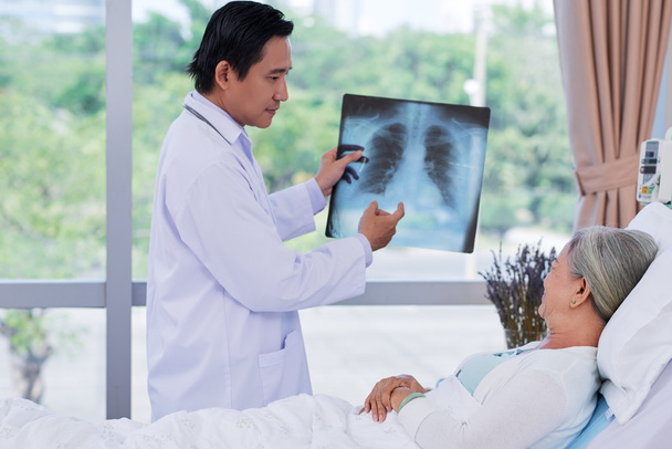 Arzt zeigt Patient Röntgenbild - Foto, Bild