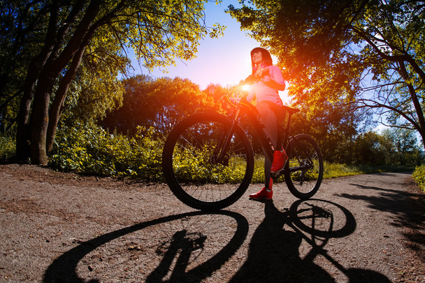 Nuori nainen hauskaa ratsastus polkupyörällä puistossa
. - Valokuva, kuva