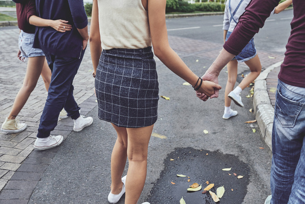 couple holding hands when walking - Fotografie, Obrázek
