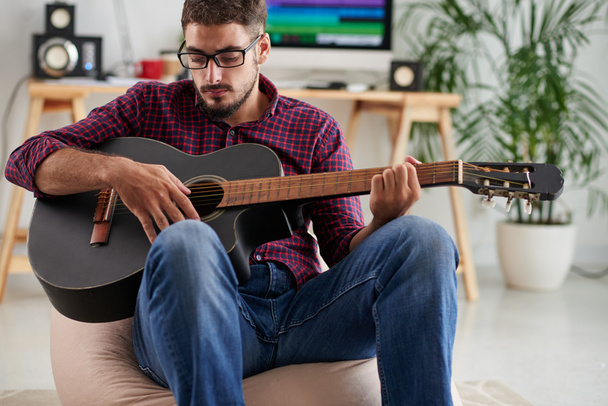 músico tocando guitarra em sua casa
 - Foto, Imagem