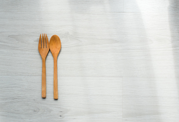 Background of a wooden spoon and fork on gray wooden floors - 写真・画像