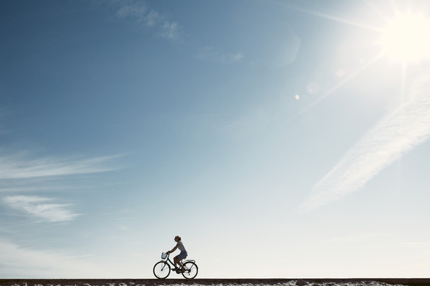自転車に乗るシルエットを楽しむ女の子 - 写真・画像