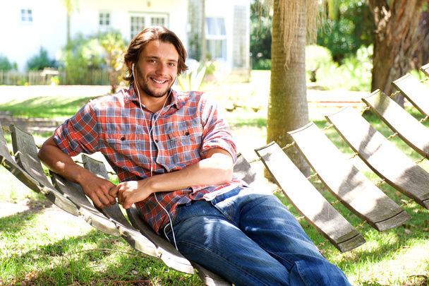 Jeune homme couché dans un hamac avec écouteurs
 - Photo, image