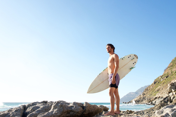Привлекательный молодой человек стоит на пляже
 - Фото, изображение