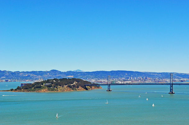 São Francisco, Califórnia: vista aérea de veleiros e da Ponte da Baía de São Francisco-Oakland, conhecida como Bay Bridge, inaugurada em 12 de novembro de 1936 no estuário raso da Baía de São Francisco
 - Foto, Imagem