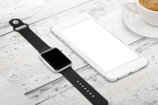 Smartwatch and phone with blank screen for mockup. Isometric view. Cup of coffee beside on table. - Photo, image