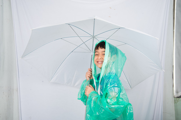 kleiner Junge mit Regenmantel auf weißem Hintergrund - Foto, Bild