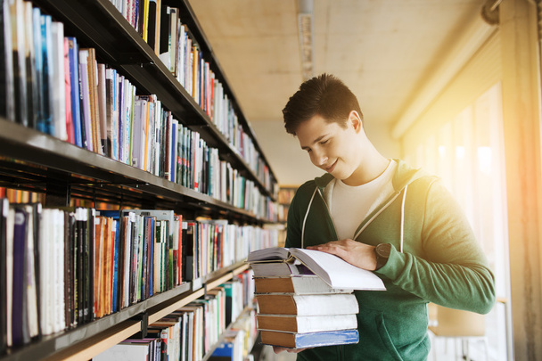 happy student or man with book in library - Photo, image