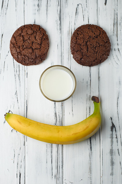 Cara engraçada da banana, leite e biscoitos
 - Foto, Imagem