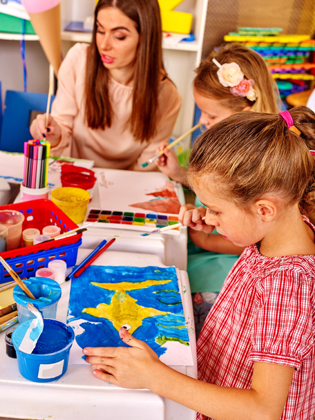 Children with teacher woman painting on paper in kindergarten . - Foto, Bild