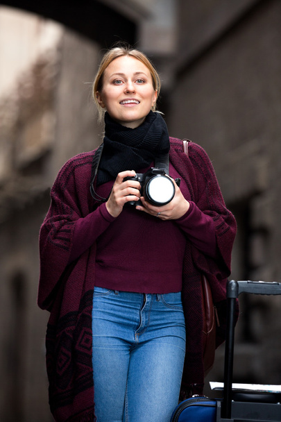Girl holding camera in hands and photographing  - Valokuva, kuva