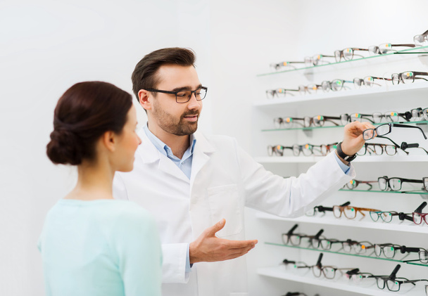 woman and optician showing glasses at optics store - Фото, зображення
