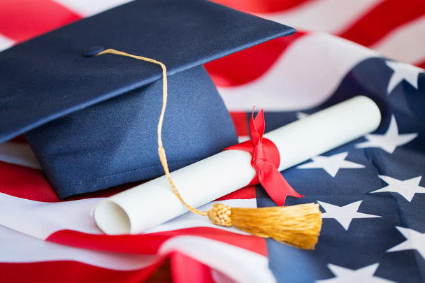 bachelor hat and diploma on american flag - Foto, afbeelding