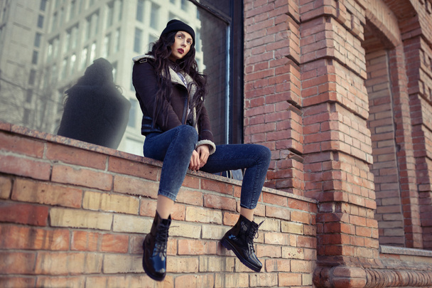 Портрет красивой молодой девушки, одетой в хипстерский гранж-стиль на городском фоне. В джинсах и шляпе. Женщина весенней моды. Тонированные фильтры Instagram
. - Фото, изображение