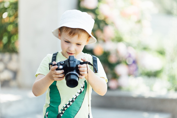 Young boy taking photos of beautiful summer background - 写真・画像