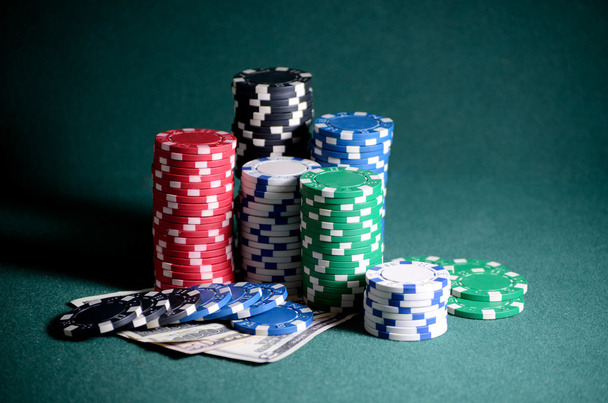 Στοίβα από μάρκες καζίνο και τους λογαριασμούς δολαρίων στο τραπέζι του πόκερ - Φωτογραφία, εικόνα