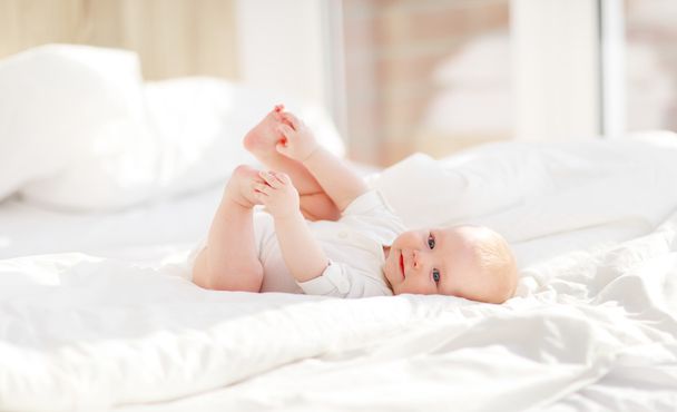 happy newborn baby on bed - Фото, изображение