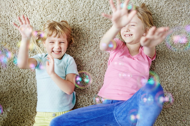 Schwestern spielen mit Seifenblasen - Foto, Bild