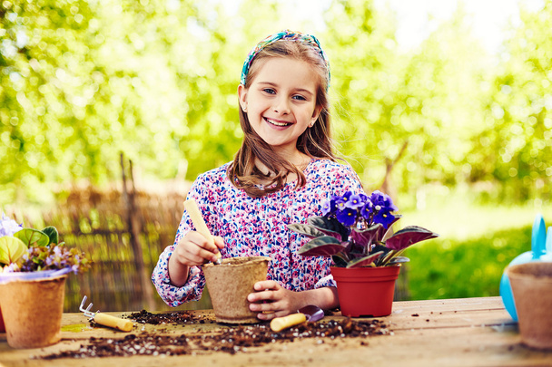  girl planting violet - Φωτογραφία, εικόνα