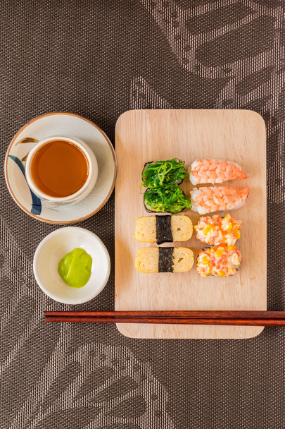 Sushi set with chop sticks, wasabi served on wooden slate, selec - Photo, Image