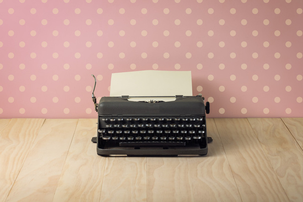 Image of vintage typewriter on pink polka dots wallpaper - Fotó, kép