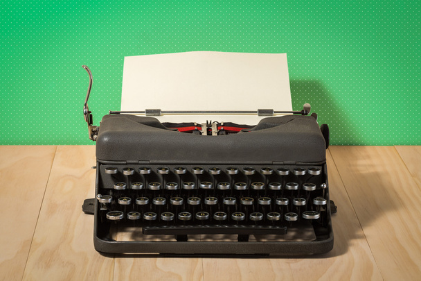 Image of vintage typewriter on green wallpaper - Fotó, kép