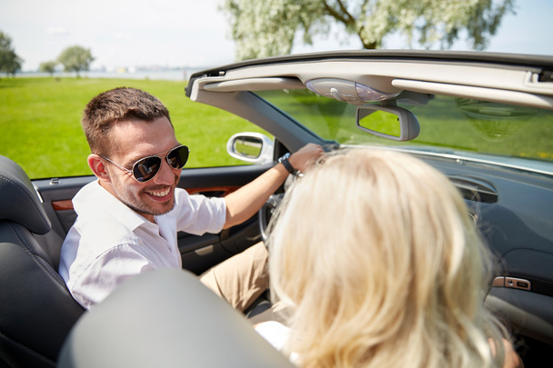 happy man and woman driving in cabriolet car - Photo, image