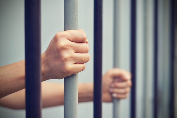 hapse mahkum kilitliydi, onu hapse esir Demir parmaklıkları el ele tutuşur. - Fotoğraf, Görsel