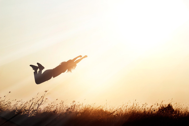  Woman flying over the meadow nature on sunset silhouette backgr - Foto, Imagem