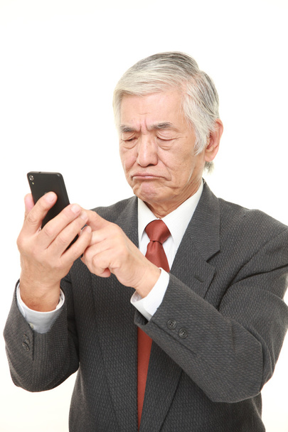 senior Japanese businessman using smart phone looking confused - Photo, Image