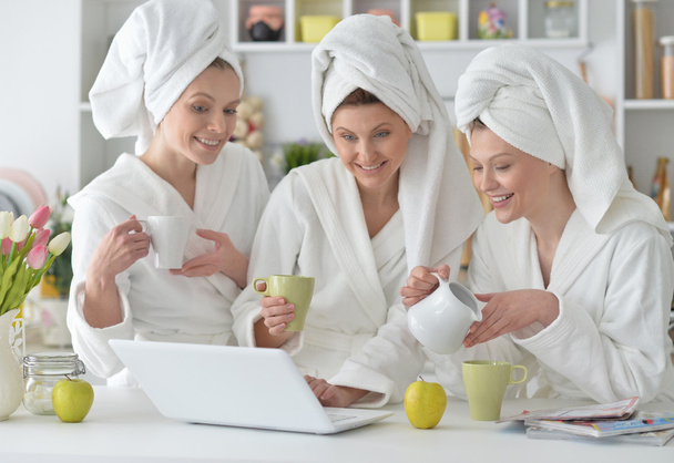women wearing a white bathrobes with laptop - Foto, Imagem