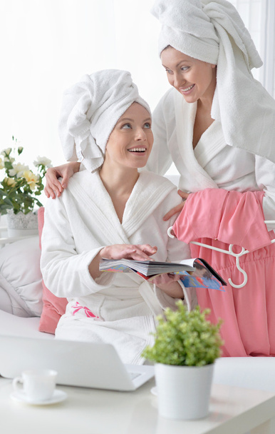 women wearing a white bathrobes with laptop - Fotó, kép