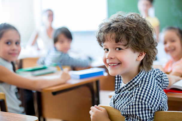 Hymyilevä poika luokkahuoneessa
 - Valokuva, kuva