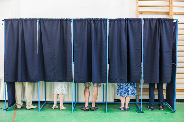 Люди голосують в кабінках
 - Фото, зображення