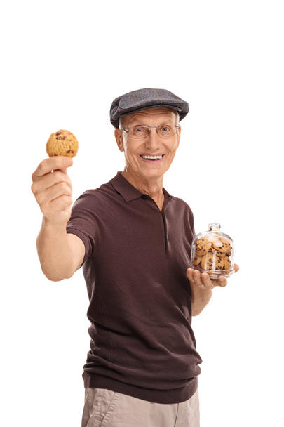 senior man holding a jar with cookies - Foto, afbeelding